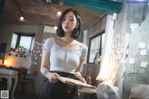 A woman sitting at a table holding a clipboard.