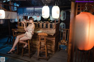 A naked asian woman in a pink kimono posing for the camera.