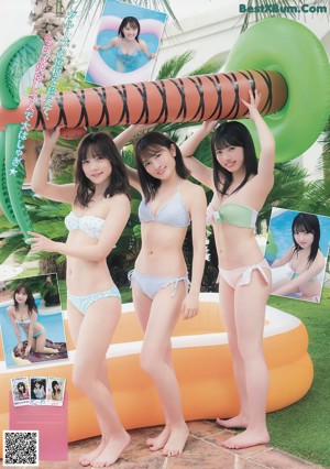 A group of three women in bikinis sitting next to each other.