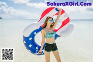 A woman in a black bikini standing on a beach.