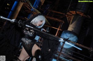 A woman in a black outfit holding a sword.