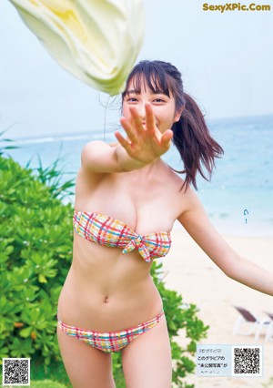 A woman in a blue bikini laying on the beach.