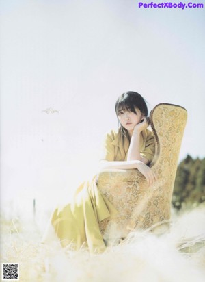 A woman standing in a field of tall grass.