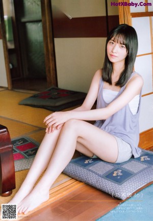 A woman sitting in a rocking chair eating a piece of fruit.