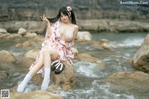 A woman in a white bikini standing in the water.