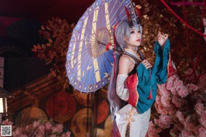 A woman in a white and red dress holding an umbrella.