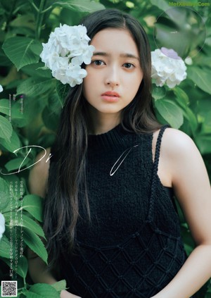 A woman with long brown hair wearing a black top.
