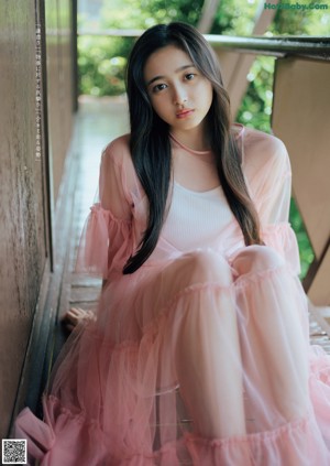 A woman with long brown hair wearing a black top.