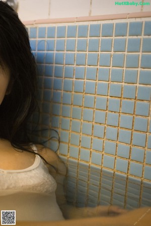 A woman laying on a mat in front of a window.