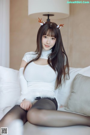 A woman in a white shirt and black stockings posing for a picture.
