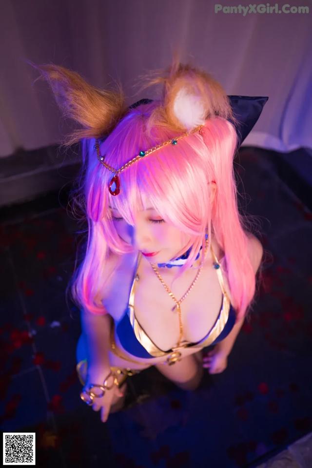 A woman with pink hair wearing a cat ears headband.