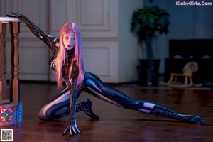 A woman in a black and white spider suit sitting on a table.