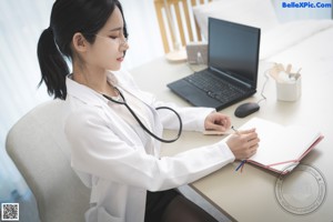 A woman in a white lab coat and black stockings sitting on a couch.