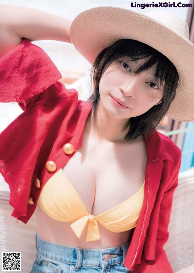 A woman in a red jacket and a yellow bikini top.