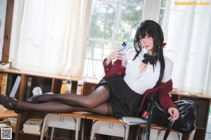 A woman sitting on the floor in a classroom.