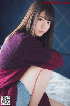 A woman sitting on the floor holding a camera.