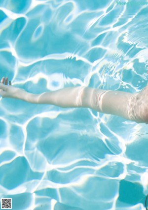 A woman in a bikini standing in a pool.