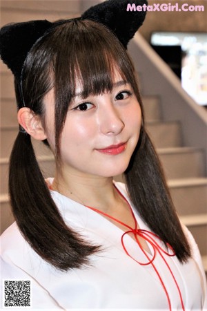 A woman in a school uniform holding a magazine.