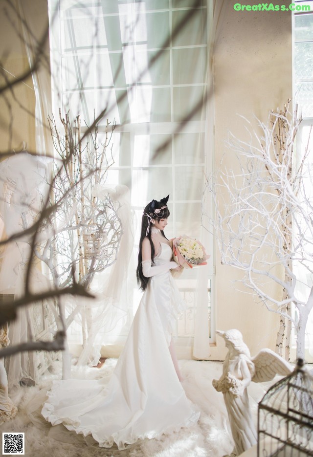 A woman in a wedding dress holding a bouquet of flowers.