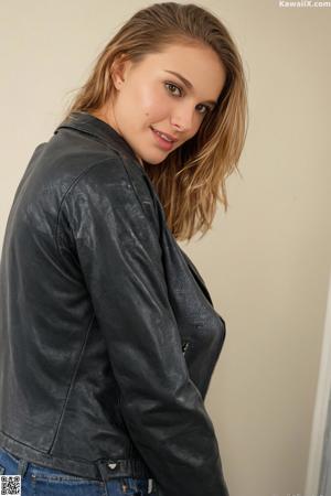 A woman in a black suit and a black hat.