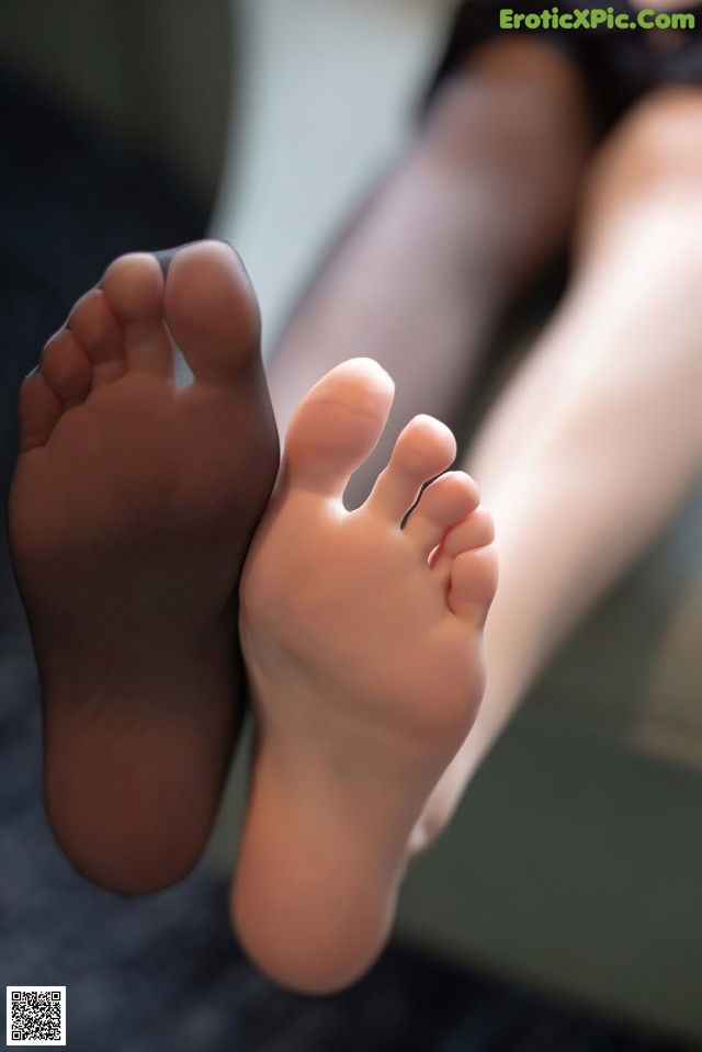 A close up of a person's feet with black stockings.