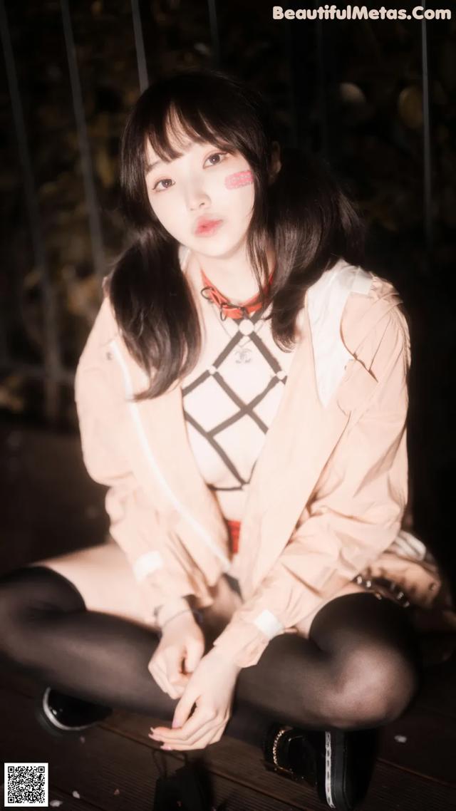 A woman sitting on top of a wooden bench.