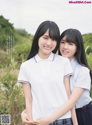 A couple of young women in school uniforms standing next to each other.