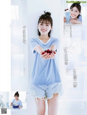 a woman wearing a blue t - shirt and denim shorts